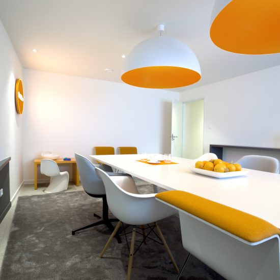 espace de réunion, tapis gris, meubles orange et blanc