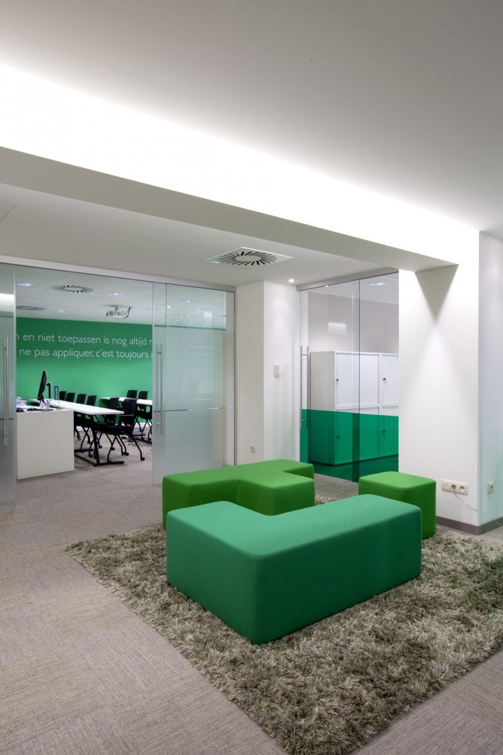 Green carpet, green sitting elements in fabric, workspace, logo Immotheker on wall