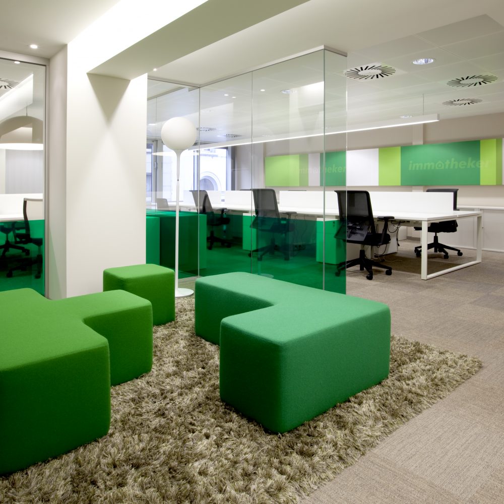 Green carpet, green sitting elements in fabric, workspace, logo Immotheker on wall